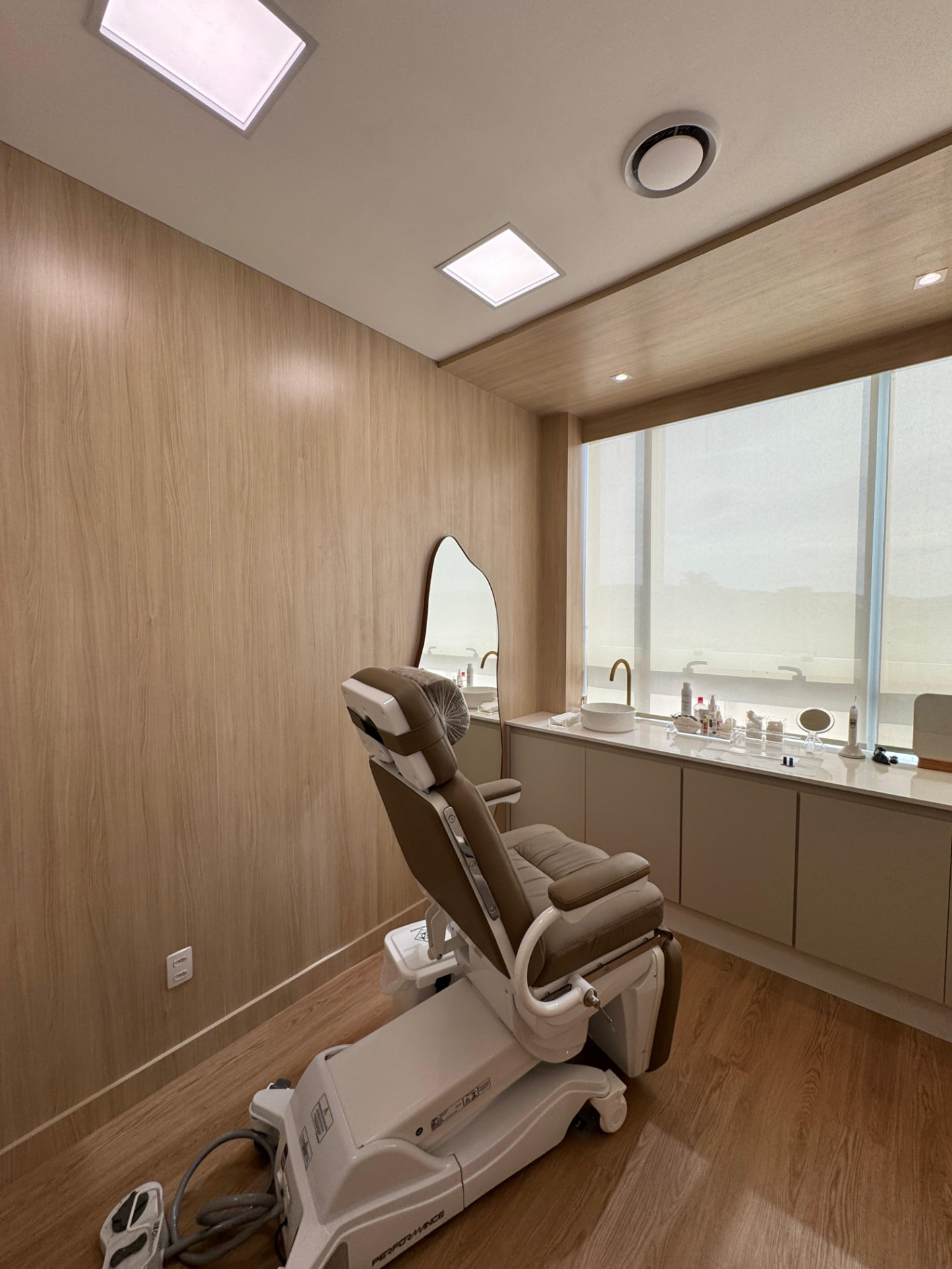 Sala de procedimentos com marcenaria clara e iluminação projetada, obra conduzida pela Integra Engenharia